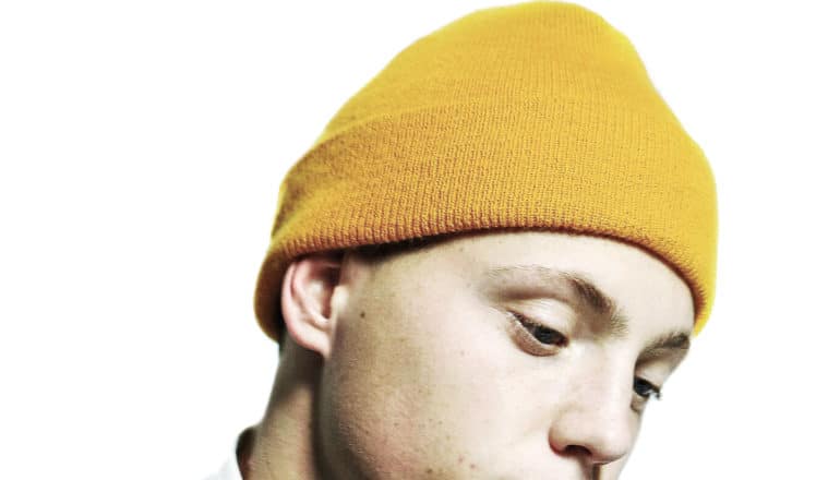 person in yellow cap stares into middle distance