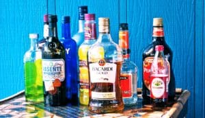 alcohol poisoning -- liquor bottles against blue wall