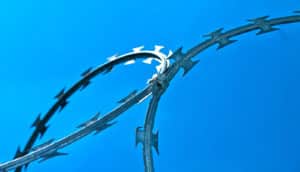 razor wire against blue sky (prison concept)