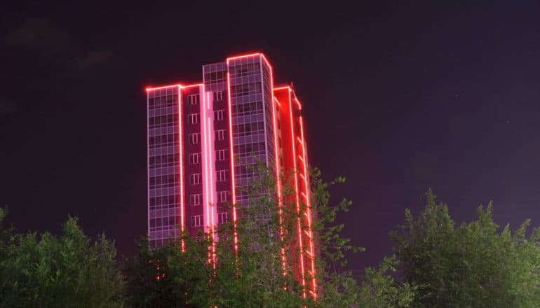 red neon lines on building in dark - redlined neighborhoods