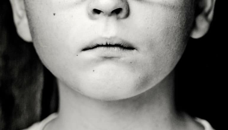black and white image of sad child's mouth
