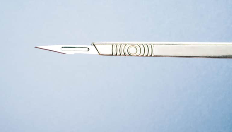 bariatric surgery - scalpel against blue background
