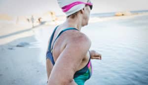 woman in swimsuit and swim cap at beach