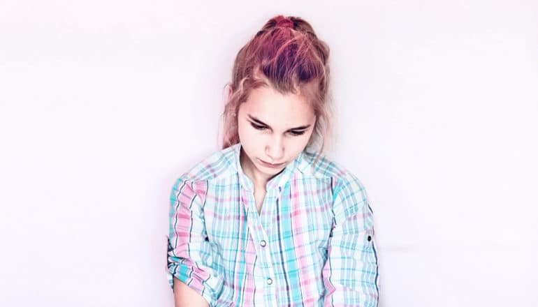 unhappy teen girl with pink hair