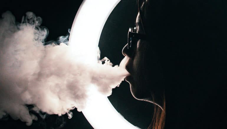 woman exhales vape smoke