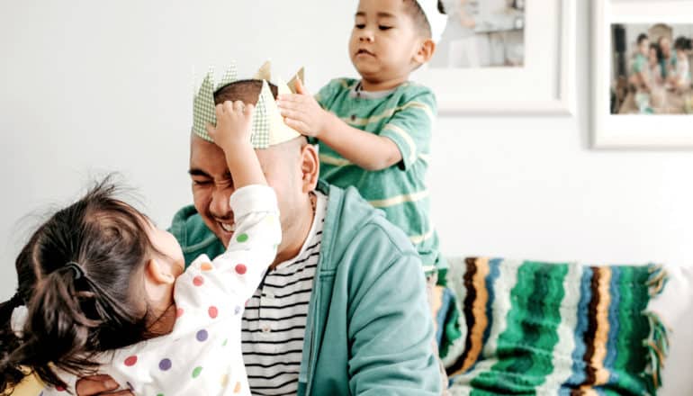 father's day - two toddlers put crown on dad's head