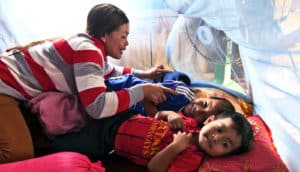 Family under mosquito net (malaria drug resistance concept)