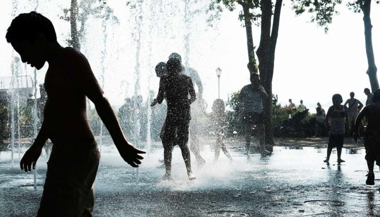 people in nyc fountain during heat wave