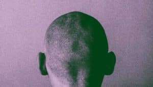 purple grainy shot of back of man's head
