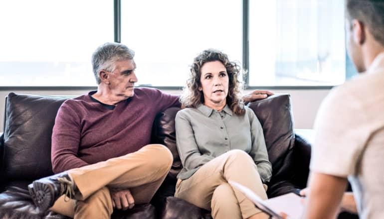 middle-aged couple on couch in counseling