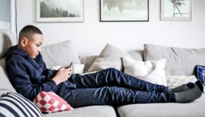lonely teen guy on couch with phone