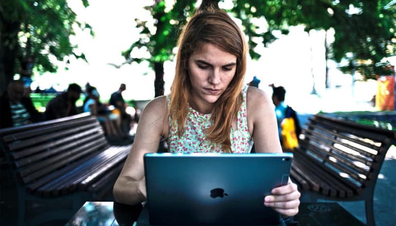 woman in park on laptop (Wikipedia gender gap concept)