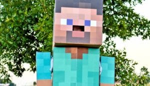 person peeks out of cardboard Minecraft costume