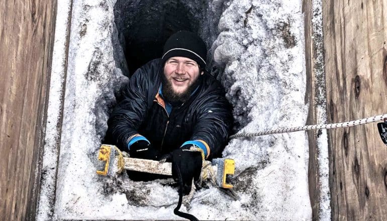 Zac Cooper climbs down an icy ladder into the tunnel (microbes concept)