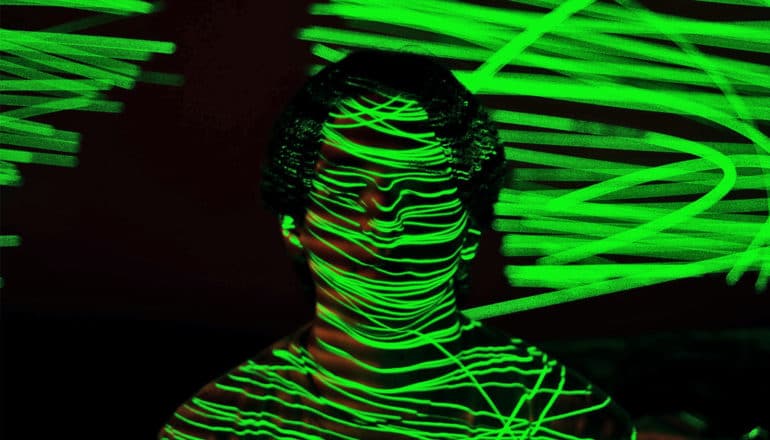 man with green lasers on face (optogenomics concept)