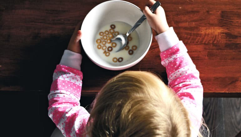 little girl eating cheerios (autism concept)