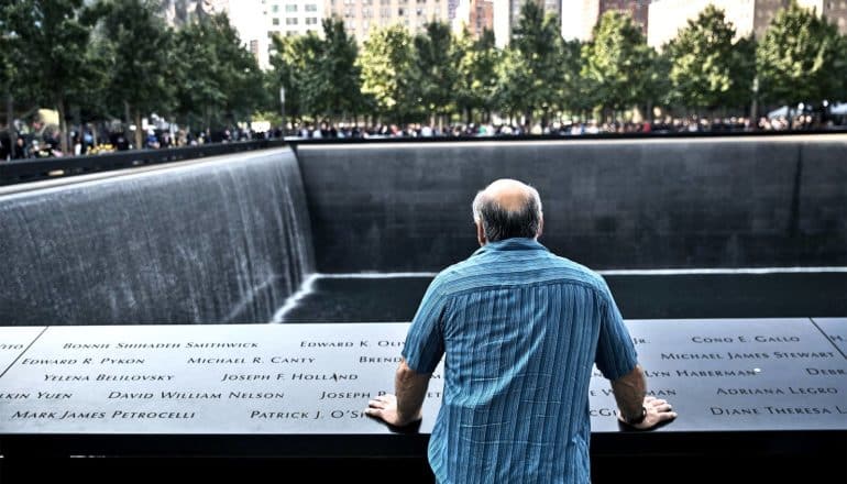 man at 9/11 memorial (trauma concept)