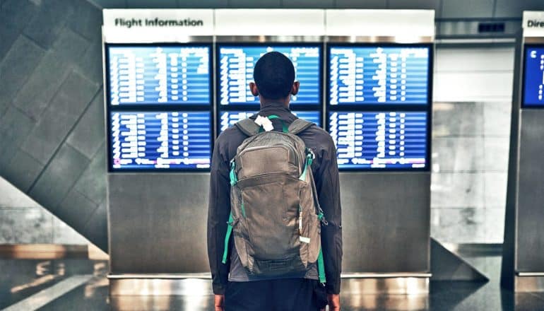 man looking at flight information (airline alliances concept)