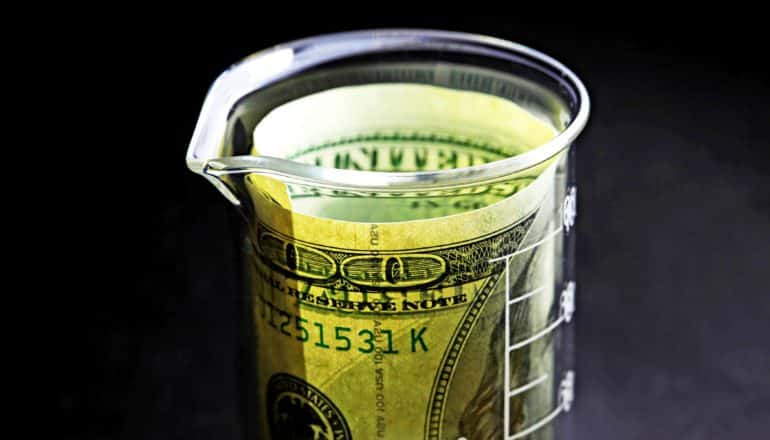 $100 bill in lab beaker - research funding