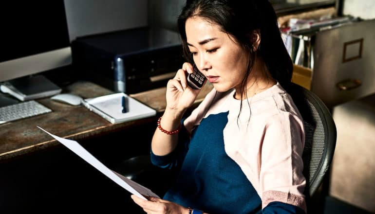 woman on phone in home office (credit counseling concept)