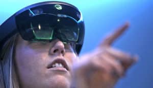 Pennington reaches out with her index finger as she looks through the black, plastic HoloLens augmented reality headset, which covers her eyes with green-looking screens.