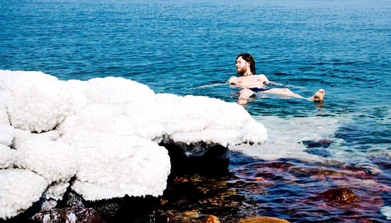 dead sea snow salt - person lounges in water
