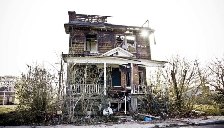 sun shines from behind abandoned building in detroit