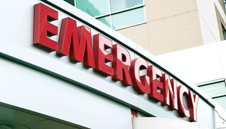 The image shows a sign on a hospital for the emergency department. (emissions concept)