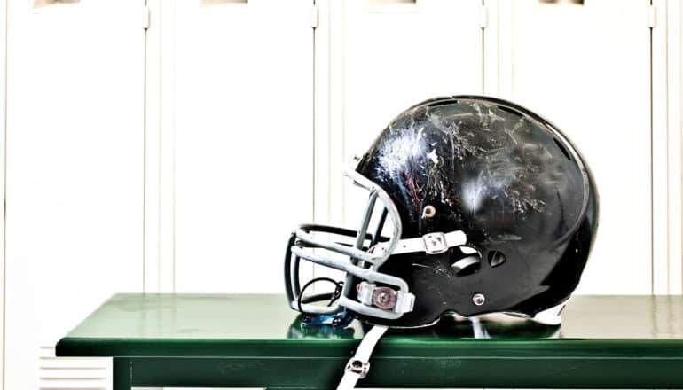 scratched football helmet on bench - CTE