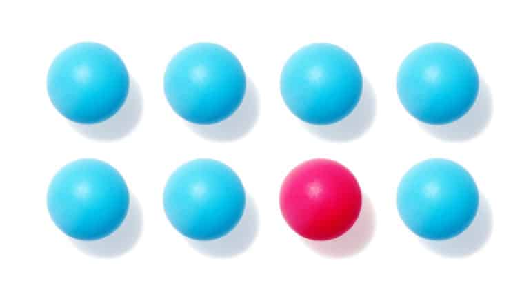 eight balls in two rows of four, one of which is pink, the rest are blue