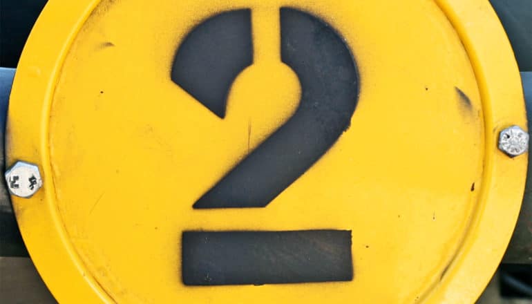 The number two is painted on a yellow pipe cover in black.