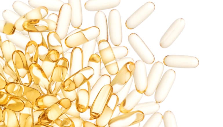 clear golden capsules spill from a pile on the right