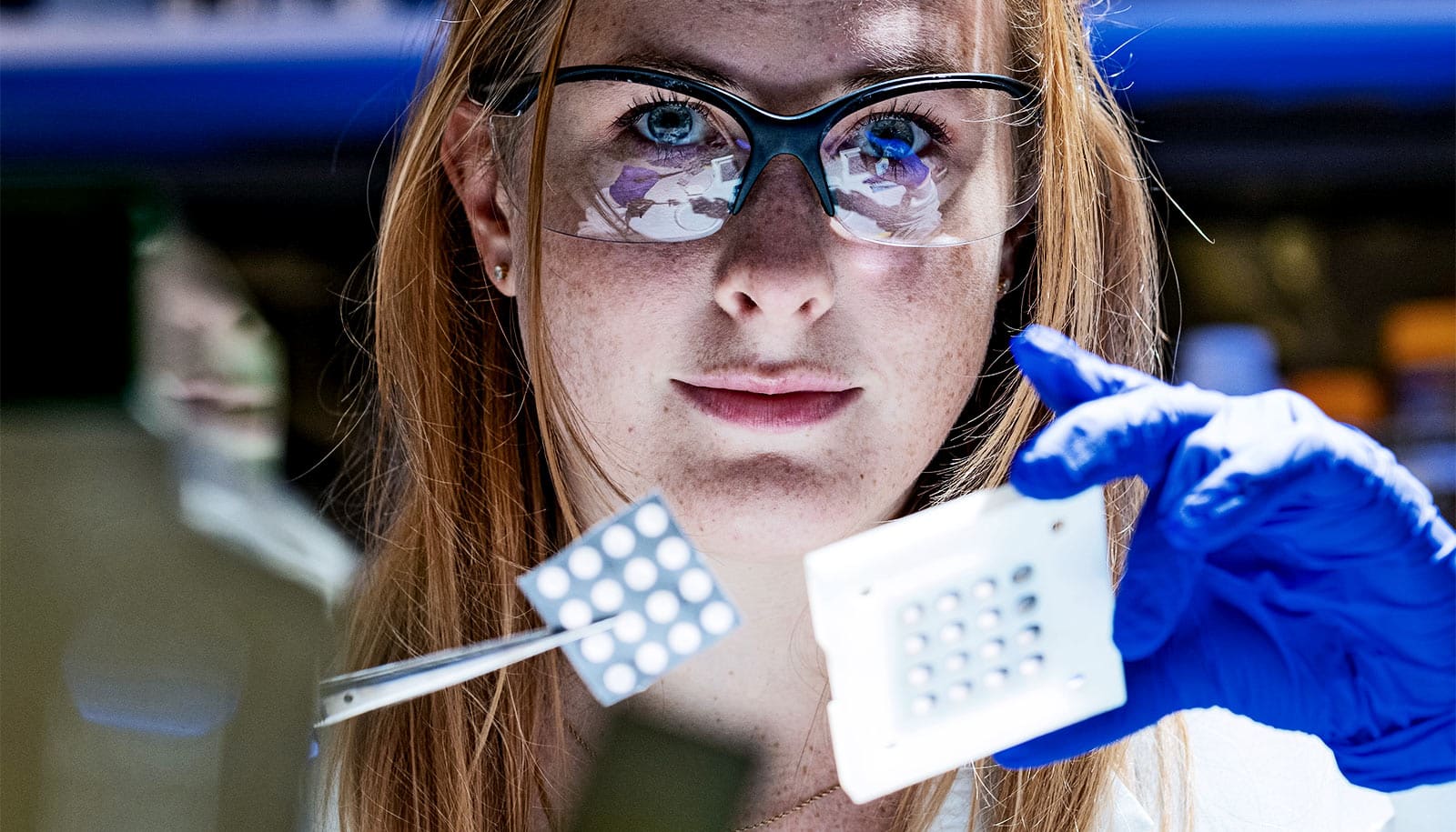 The image shows a researcher with the experimental paper device to study heart disease.