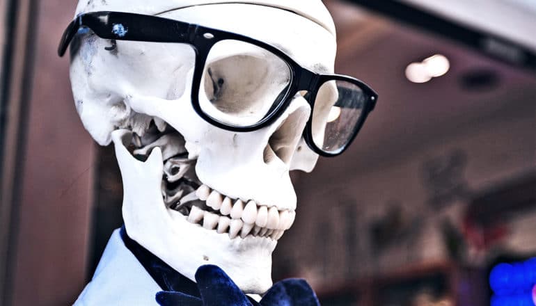A skeleton wears glasses and a bow-tie on