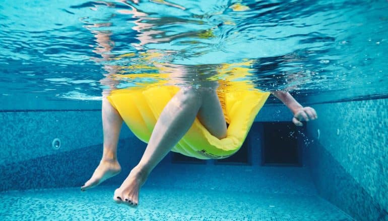 bottom half of swimmer in pool on yellow float - whole genome sequencing