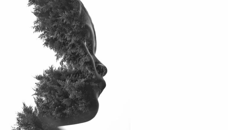 double exposure of child's profile and forest
