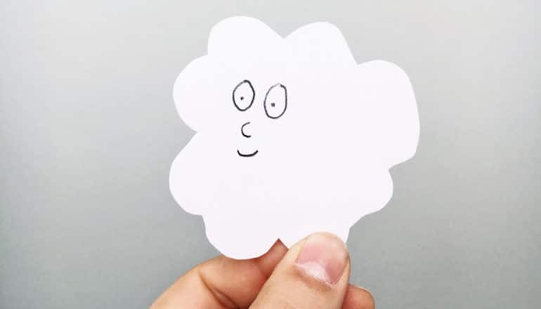 hand holds white paper cloud with friendly face