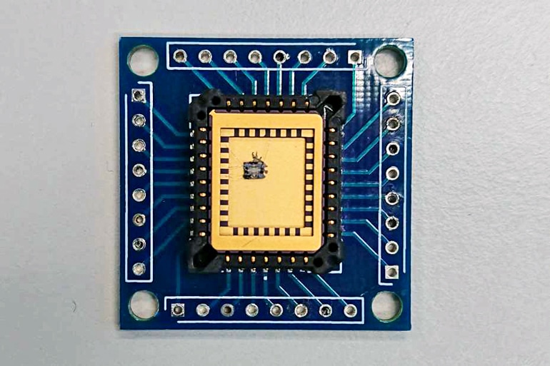 A microchip device looks blue with a gold square in the center where the alcohol sensor sits