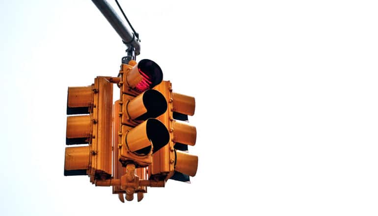 A red traffic light sits on a white background