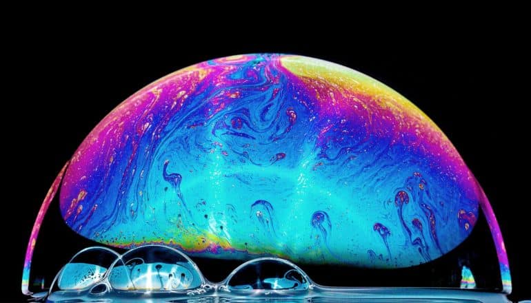 A soap bubble shows a huge range of colors as it sits against a black background