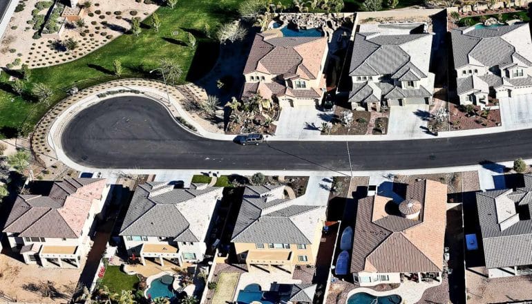 aerial view of cul de sac with large houses with pools