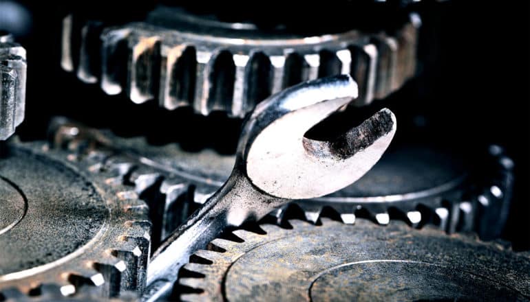 A wrench is stuck between metal gears