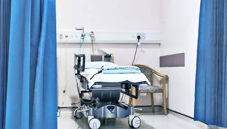 emergency room bed and chair between curtains