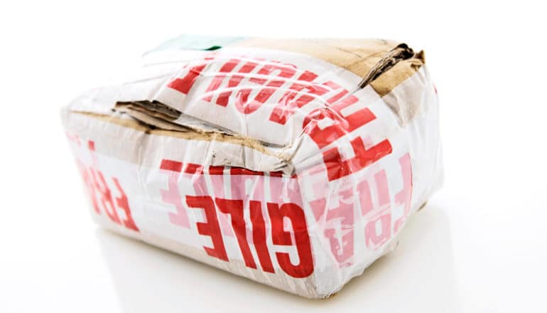 A damaged package has "fragile" stickers all over it
