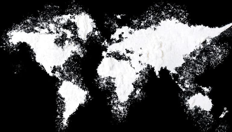 A world map made of a white powder that looks like cocaine