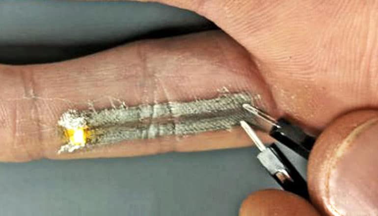 The tattoo made with printed electronic conducts a voltage that lights up the LED on the grad student's pinky finger