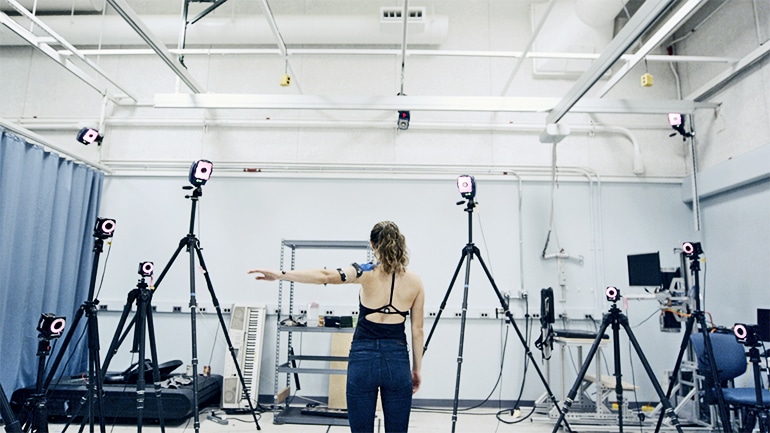 A researcher wearing the patch lifts her arm as cameras surrounding her monitor her movement