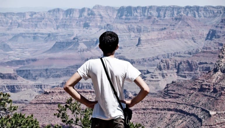 A man looks over the Grand Canyon with his hands on his hips