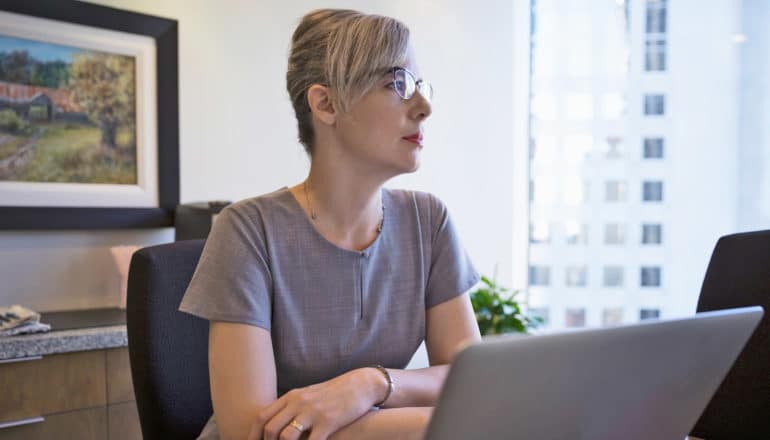 serious person sits at desk in office