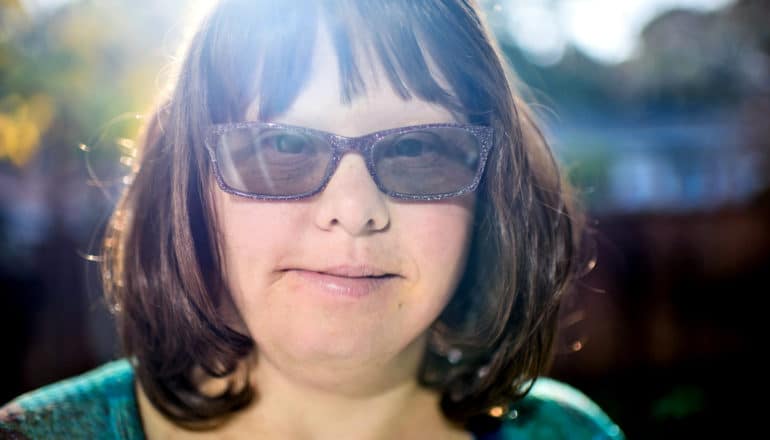 woman with down syndrome in sunglasses, slight smile